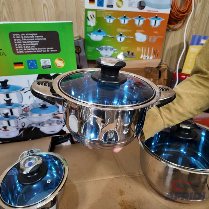 A shiny silver cooking pot with a blue-tinted glass lid and black knob.