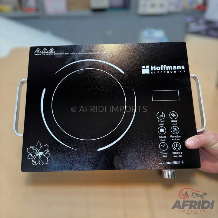 Black induction cooktop with touch controls and dual handles.