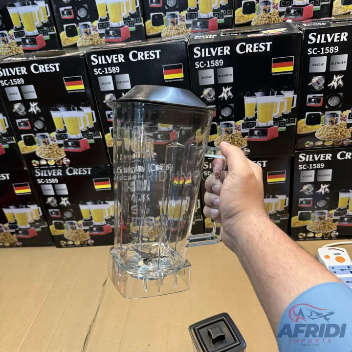 Clear plastic blender jar with a black lid and a metal blade at the bottom.