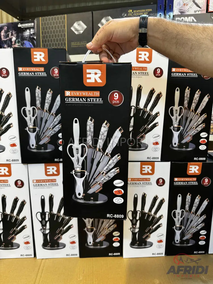 A set of 9 German steel knives with a peeler and scissors, organized in a sleek stand.