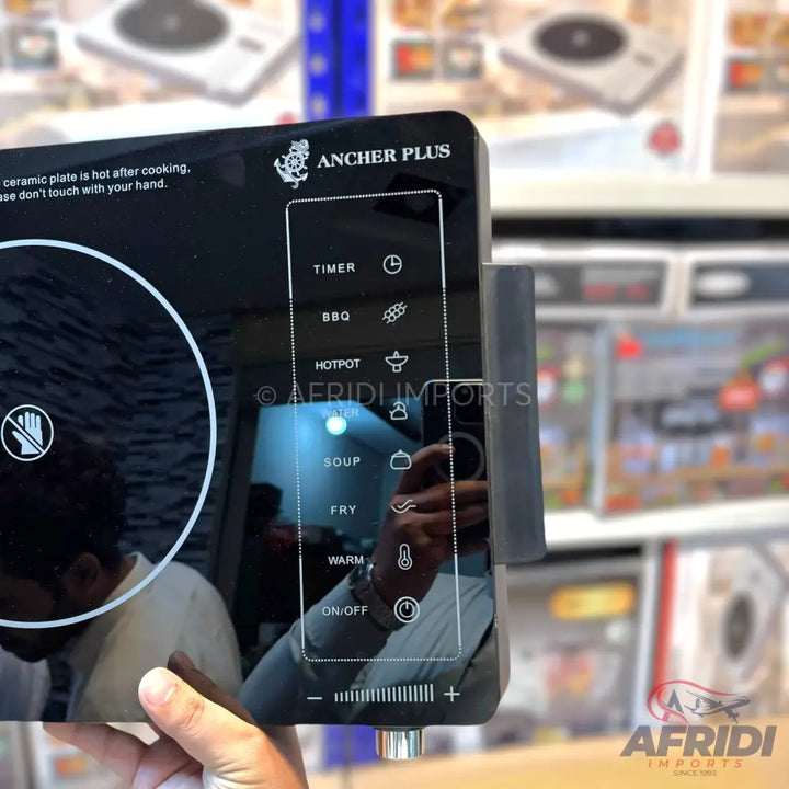 A portable, multi-function induction cooktop with a sleek black glass surface and touch controls.