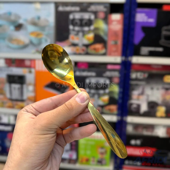 Gold-colored stainless steel spoon.
