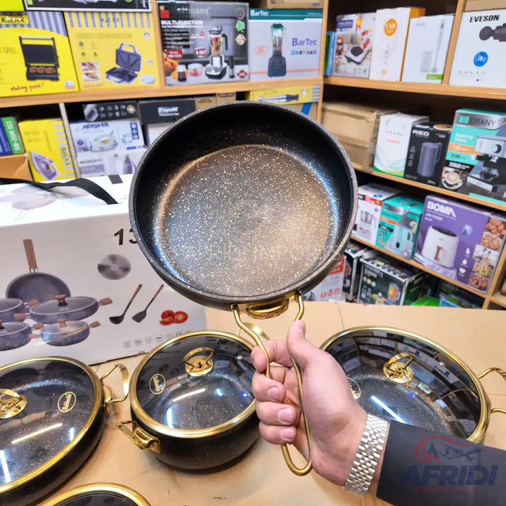 Black speckled non-stick frying pan with a golden handle.