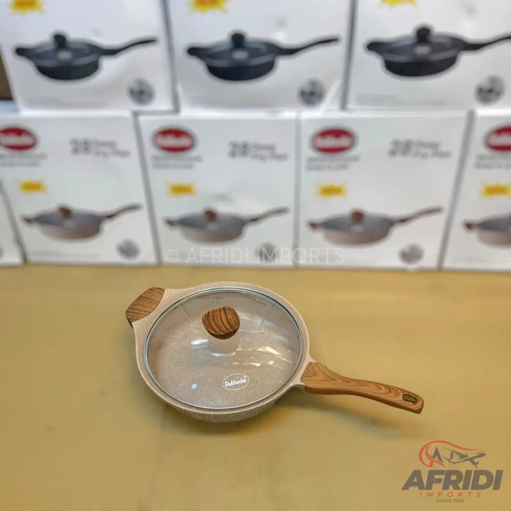 Light-colored non-stick frying pan with a glass lid and wooden handles.