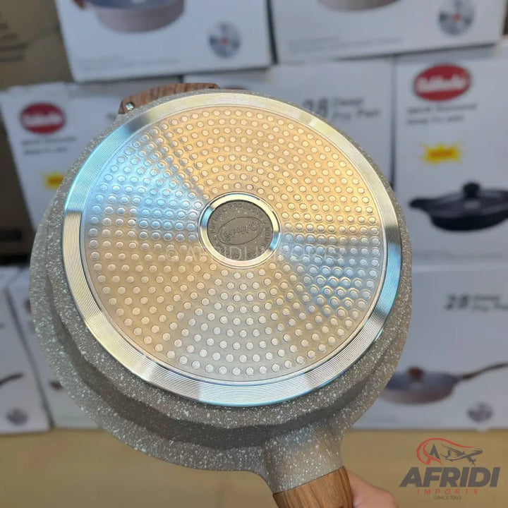 Gray speckled frying pan with a textured base and wooden handle.