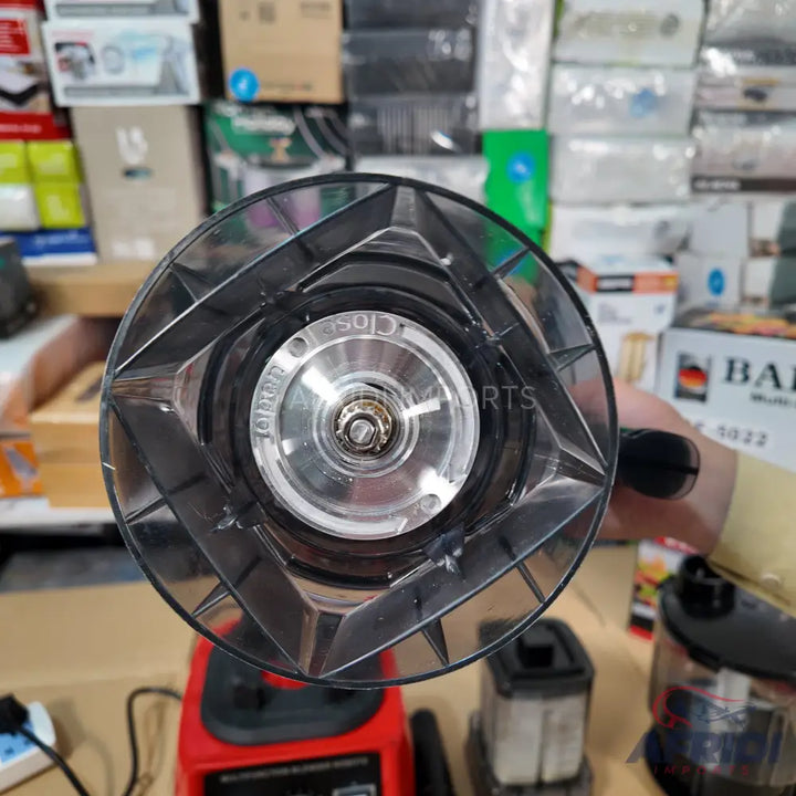 A clear plastic blender jar with a metal blade assembly.