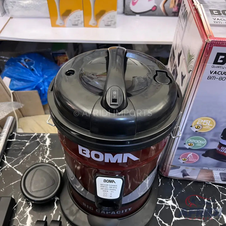 Red and black drum-style vacuum cleaner with a top handle and power switch.
