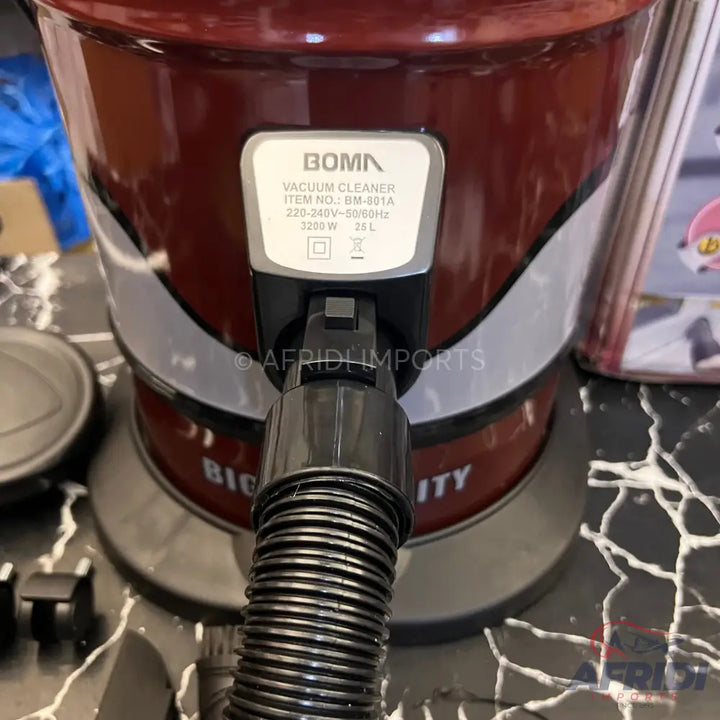 A red vacuum cleaner with a black hose connected.