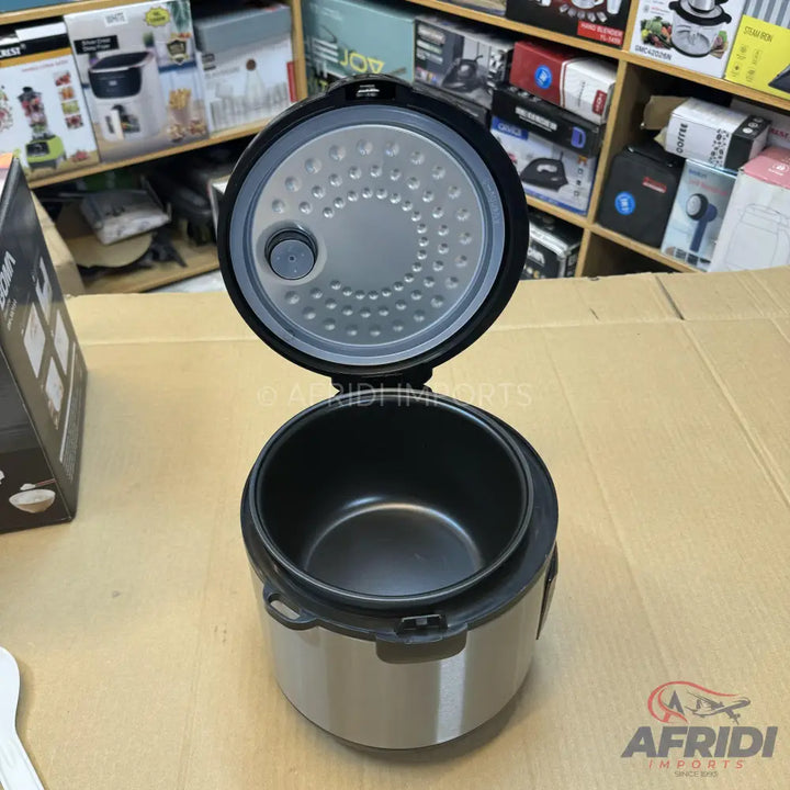 An open, stainless steel rice cooker with a non-stick inner pot.