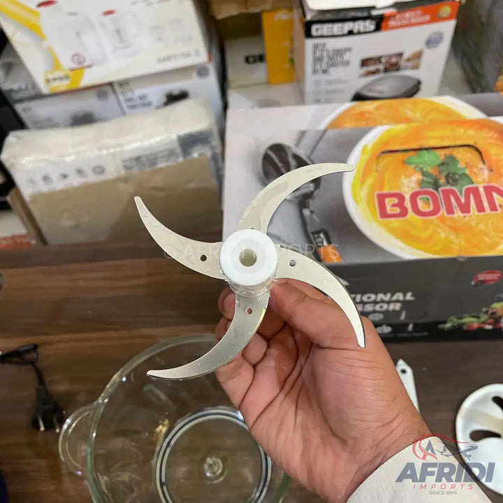 A three-bladed food processor attachment with a white plastic hub.