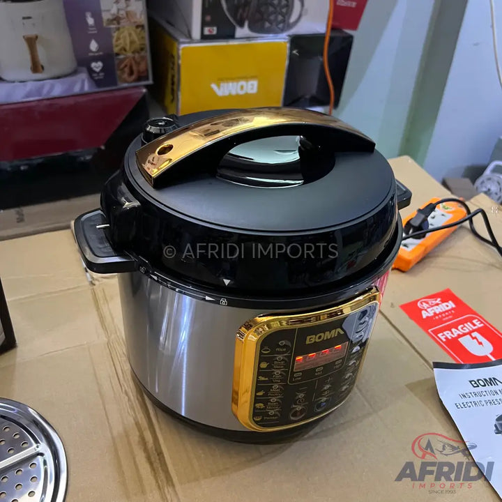 A modern electric pressure cooker with a black lid and gold accents, featuring a digital display and various cooking presets.
