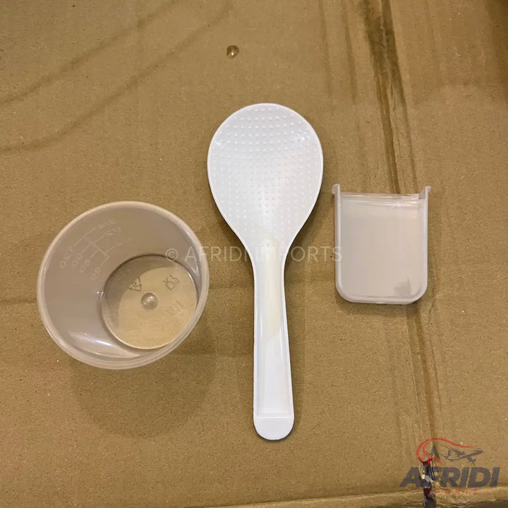 A set of translucent plastic measuring tools including a cup, a spoon, and a small rectangular container.