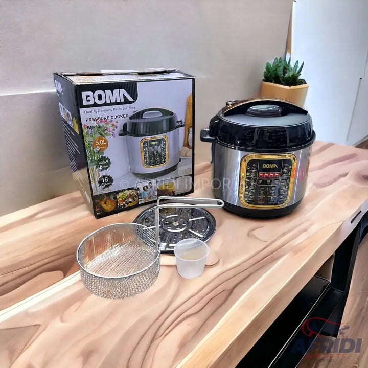 A multi-functional electric pressure cooker with a digital display and golden accents, accompanied by its packaging and accessories like a frying basket, steaming rack, and measuring cup.