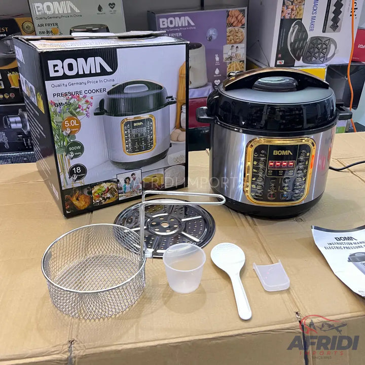 Boma 5-liter electric pressure cooker with a stainless steel pot, digital controls, and accessories including a frying basket, steaming rack, measuring cup, and spoon.
