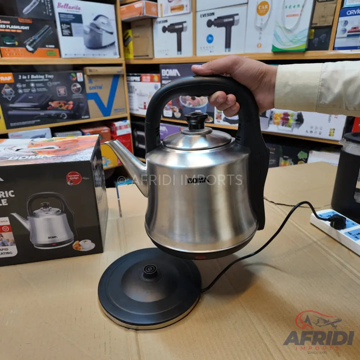 A stainless steel electric kettle with a black handle and base.