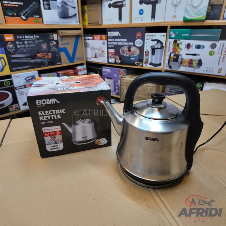 A stainless steel electric kettle with a black handle and base.