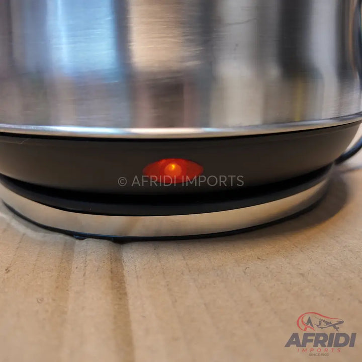 Stainless steel electric kettle with an illuminated power indicator light.