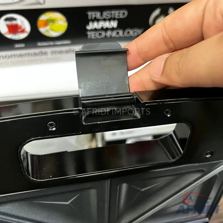 Black sandwich maker with a locking clip.