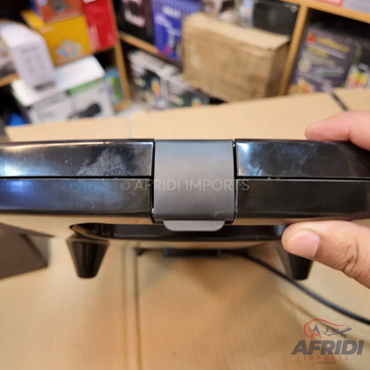 A black, closed panini press or waffle maker with a latch.