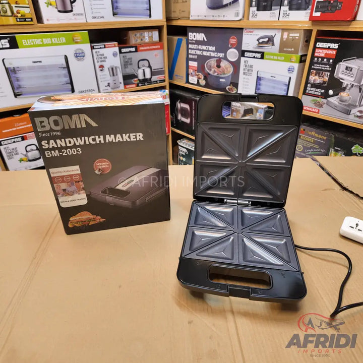 Black sandwich maker with an open non-stick cooking surface, capable of making four triangular sandwiches at once.