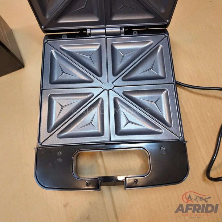 Open electric sandwich maker with four triangular compartments.