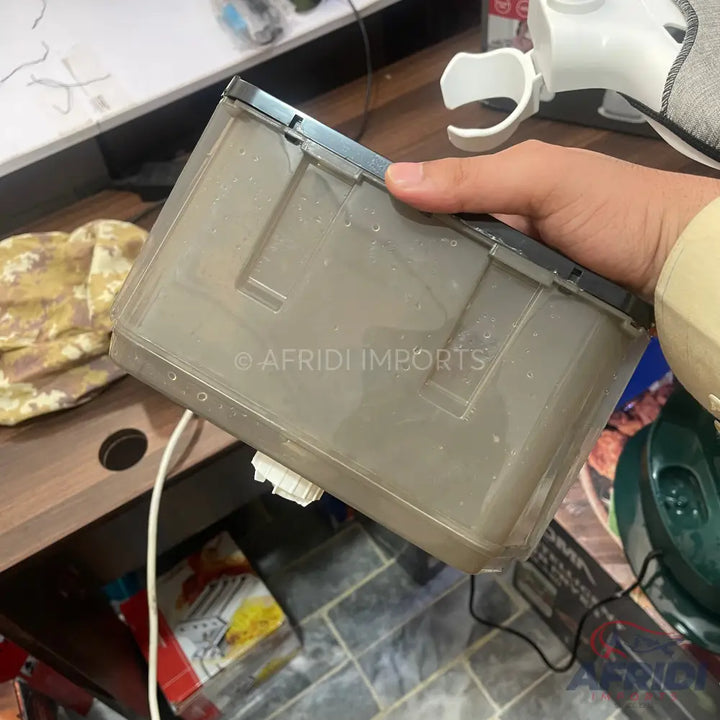 A rectangular, translucent gray plastic container with a black lid.