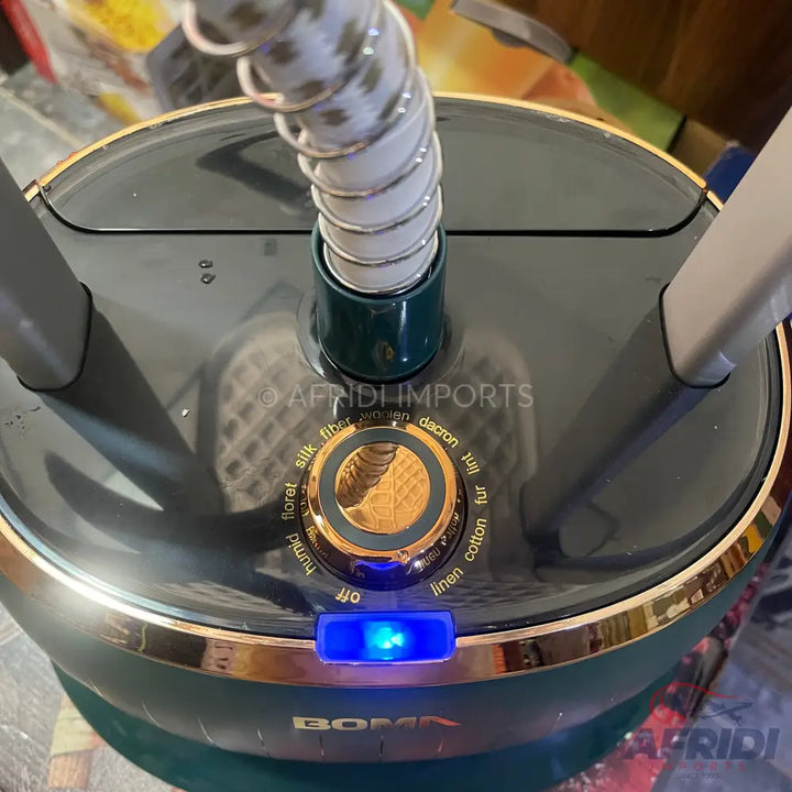 Dark green and gold garment steamer with a flexible hose and fabric-type selector.