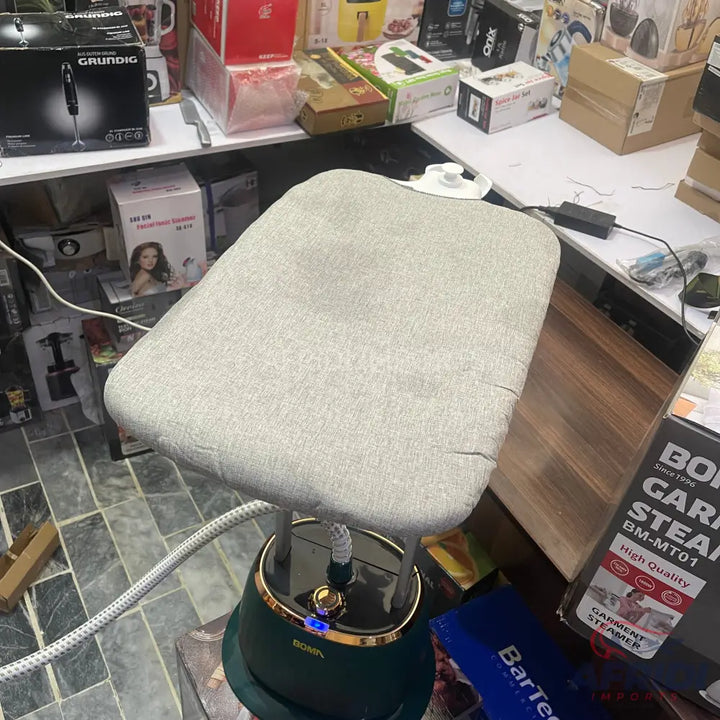 A dark green garment steamer with a light gray ironing board.