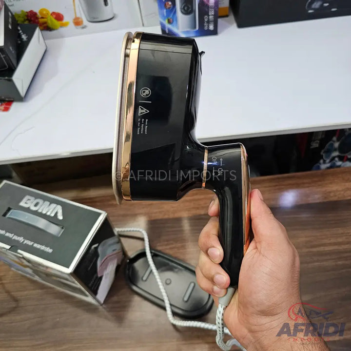 Black and gold handheld garment steamer.