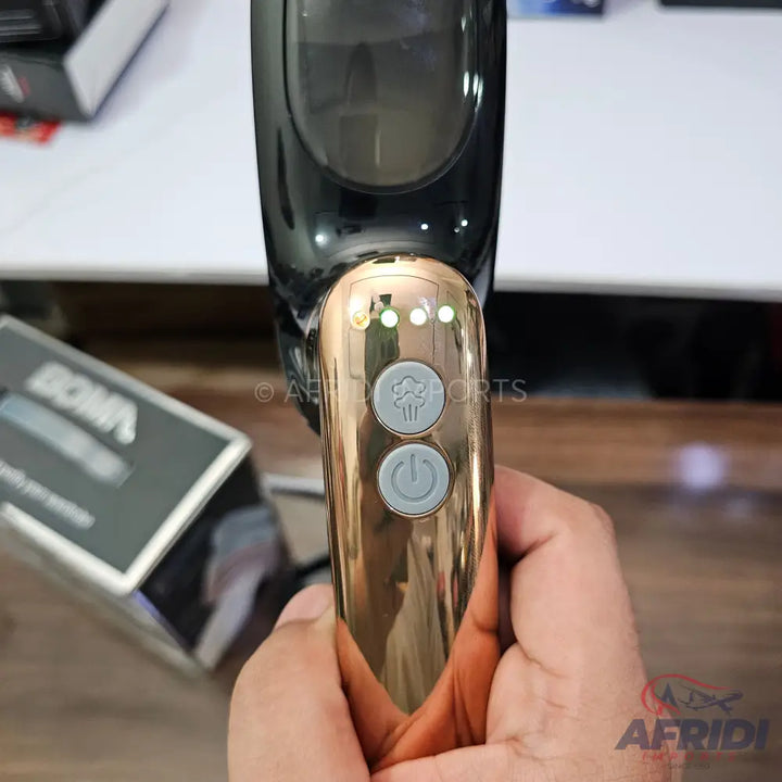 Handheld garment steamer with a gold-colored body and two control buttons.
