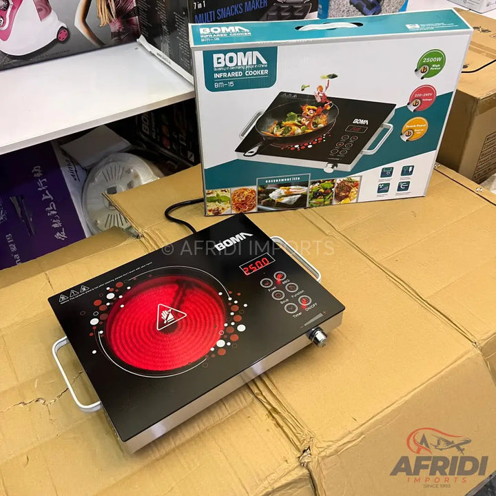 A Boma infrared cooker with a black glass top, red heating element, and digital display.