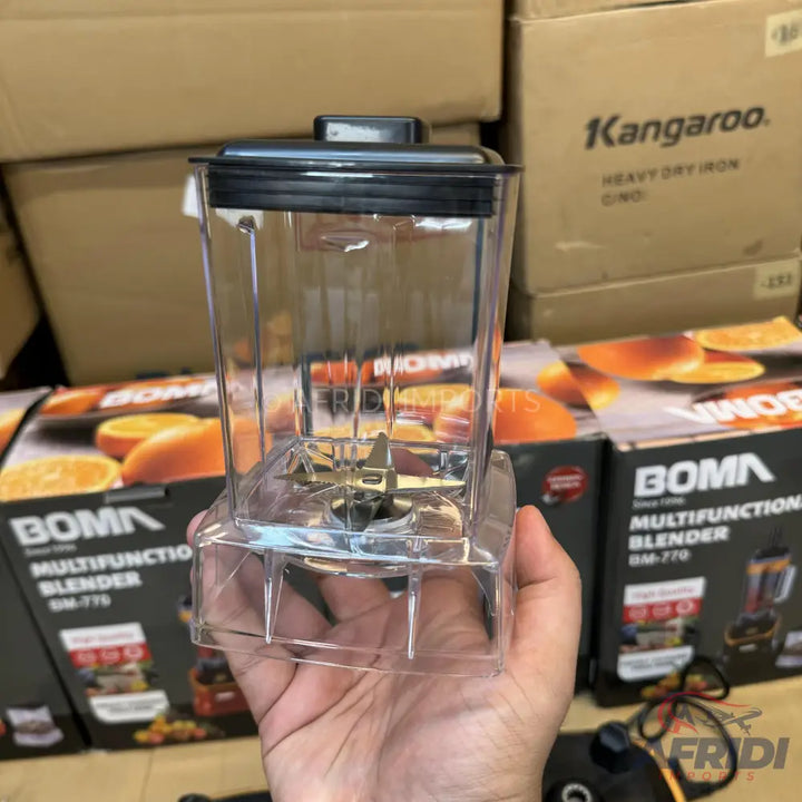 A clear plastic blender jar with a black lid and metal blades.