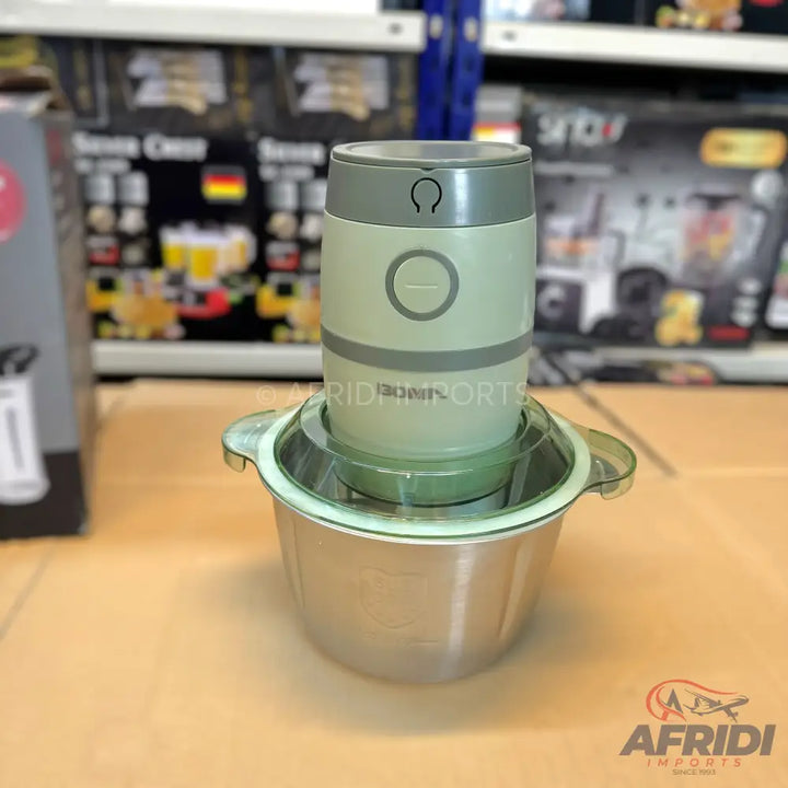 A light green and silver electric food chopper with a stainless steel bowl.