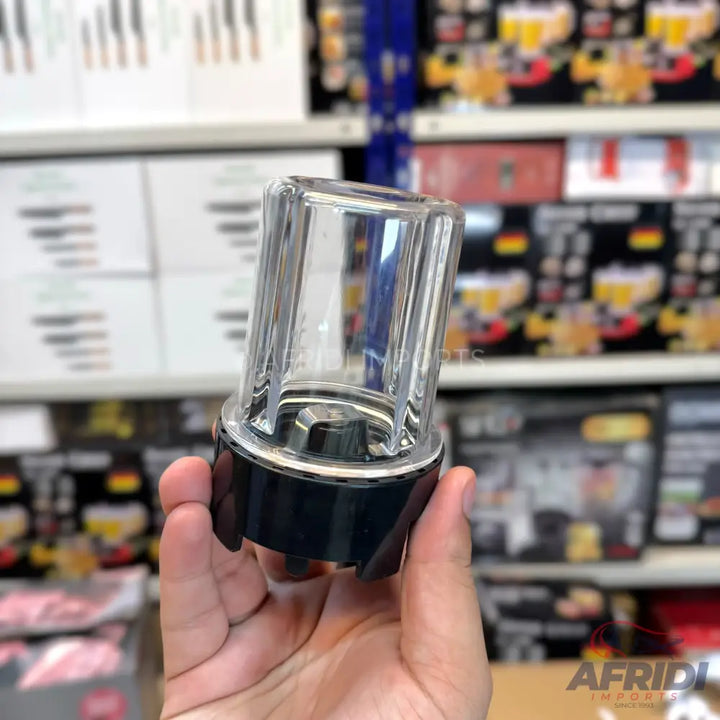 A transparent plastic and black base blender cup with a rotating blade mechanism at the bottom.