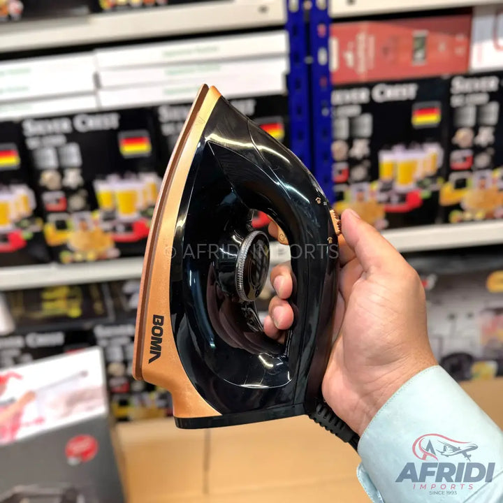 A black and copper electric iron with a temperature dial.