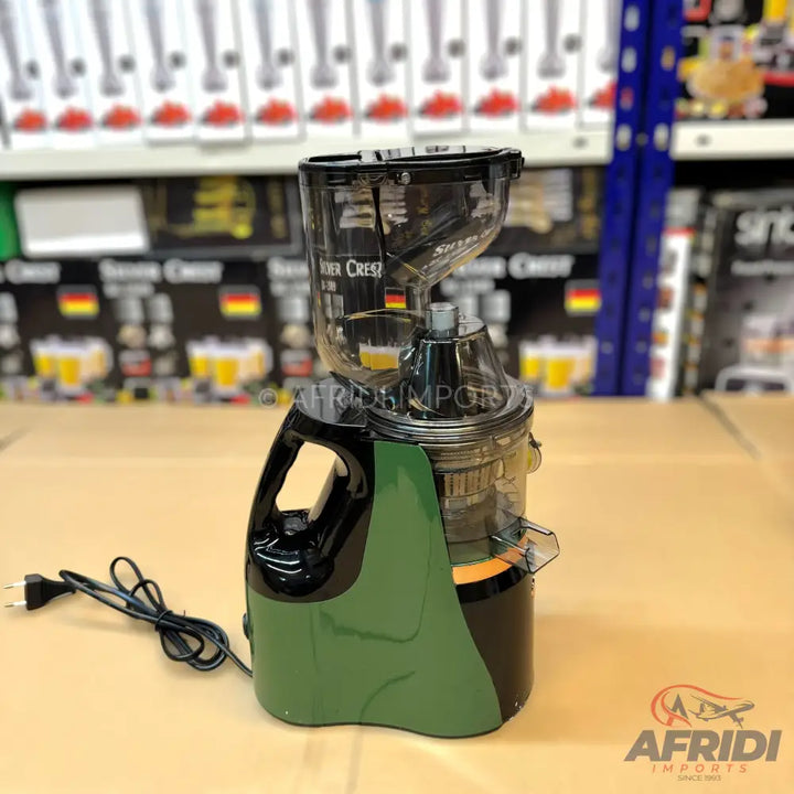 Green and black slow juicer with a transparent top.