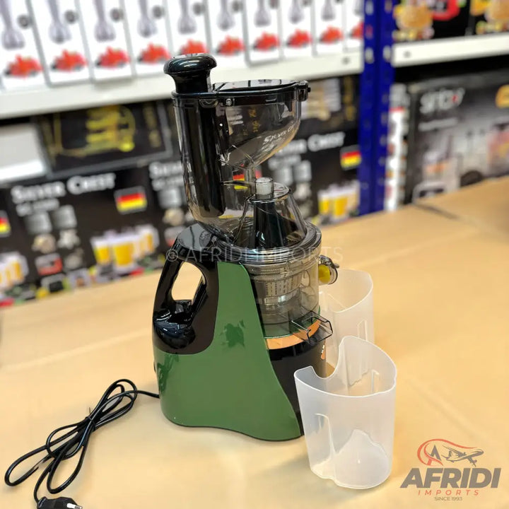 A green and black masticating juicer with two clear collection cups.