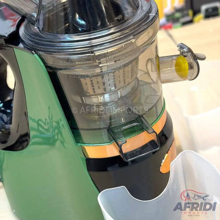 A green and black slow masticating juicer with a clear pulp spout and a transparent juicing chamber.