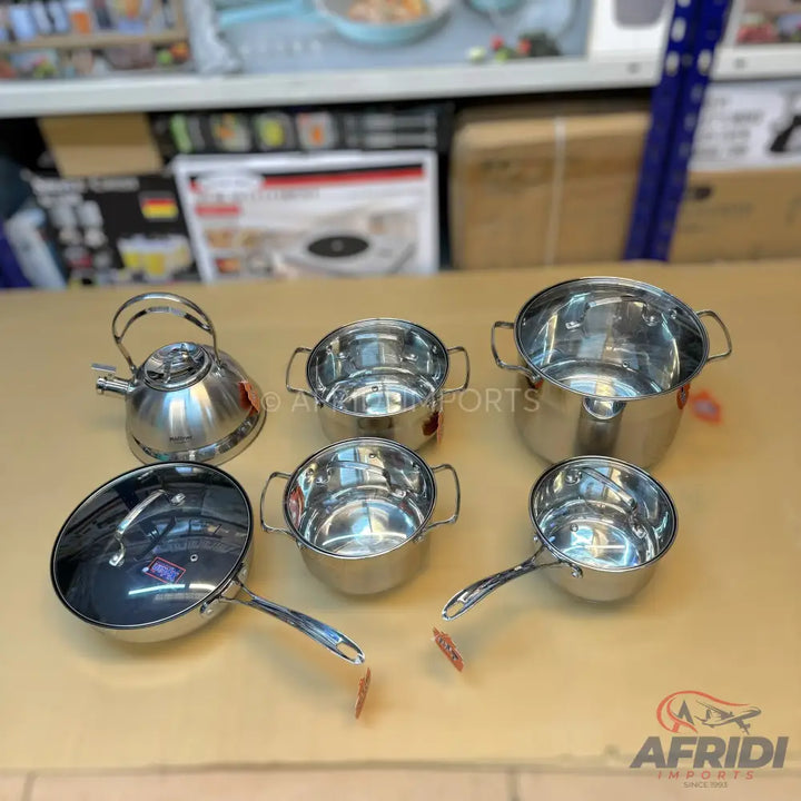 A set of stainless steel cookware, including pots, a frying pan with a lid, and a kettle.