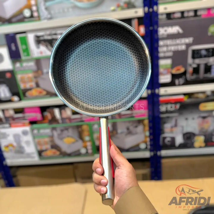 A stainless steel frying pan with a honeycomb pattern non-stick surface.
