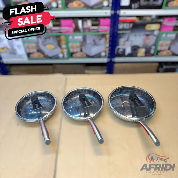 Set of three stainless steel frying pans with glass lids and red handles.