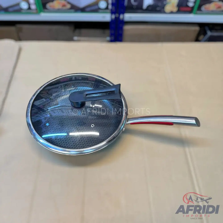 Stainless steel frying pan with a glass lid and a stay-cool handle.