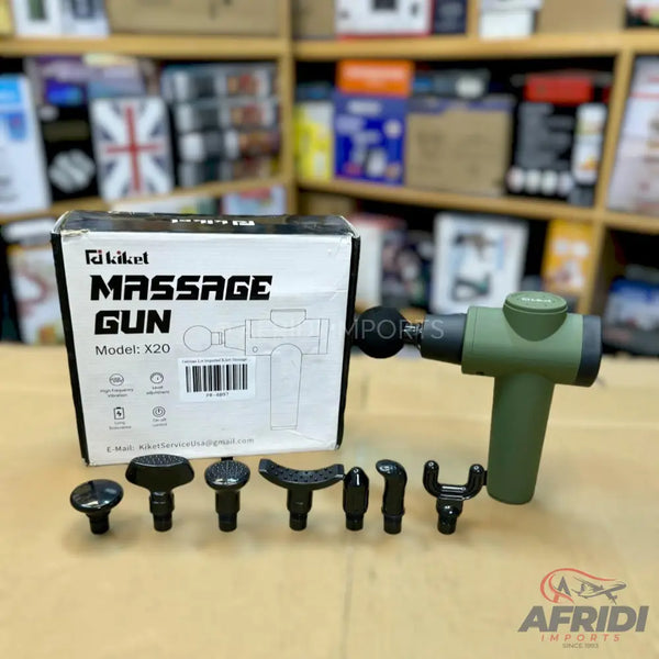 A green massage gun with various interchangeable head attachments and its packaging.