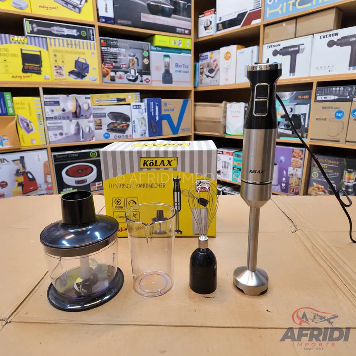 A stainless steel and black immersion blender with multiple attachments including a whisk, a chopper, and a measuring cup.
