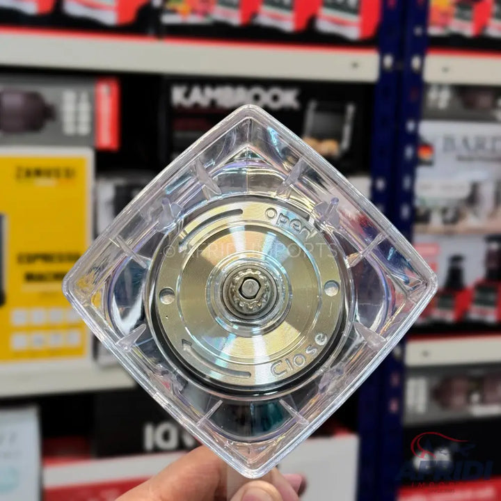 A clear plastic blender base with a silver-colored blade assembly and a central gear.