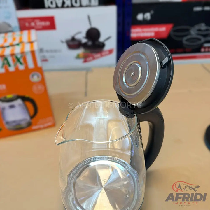 A clear glass electric kettle with an open lid.