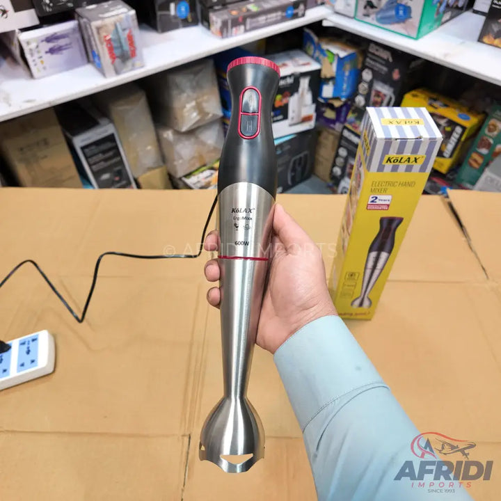 Handheld immersion blender with a black and silver body, featuring a pink accent on the top and a stainless steel blending shaft.