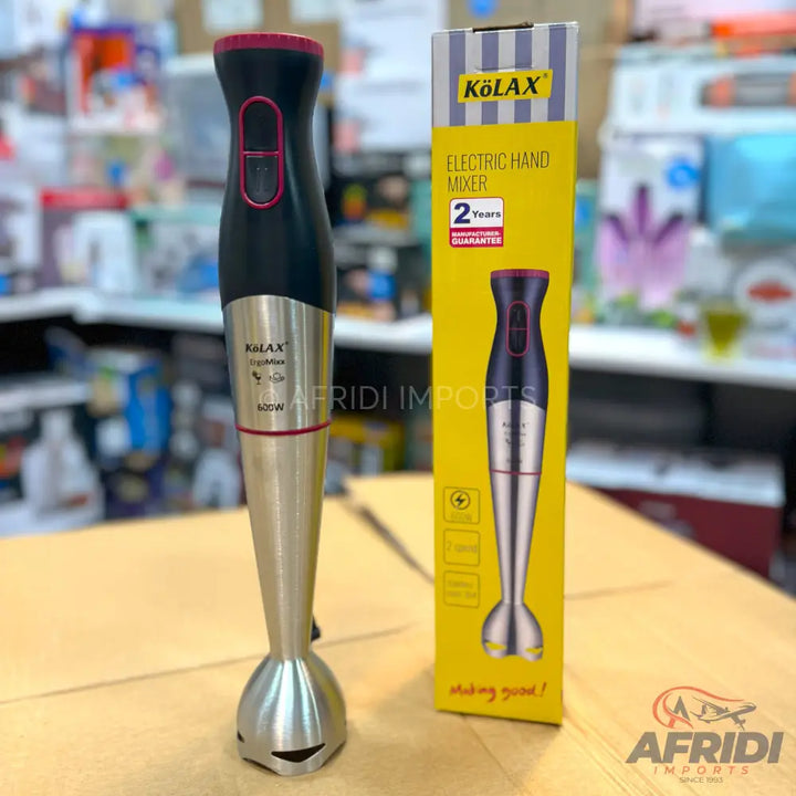 A black and silver immersion blender with a red top and power buttons, packaged in a yellow box.