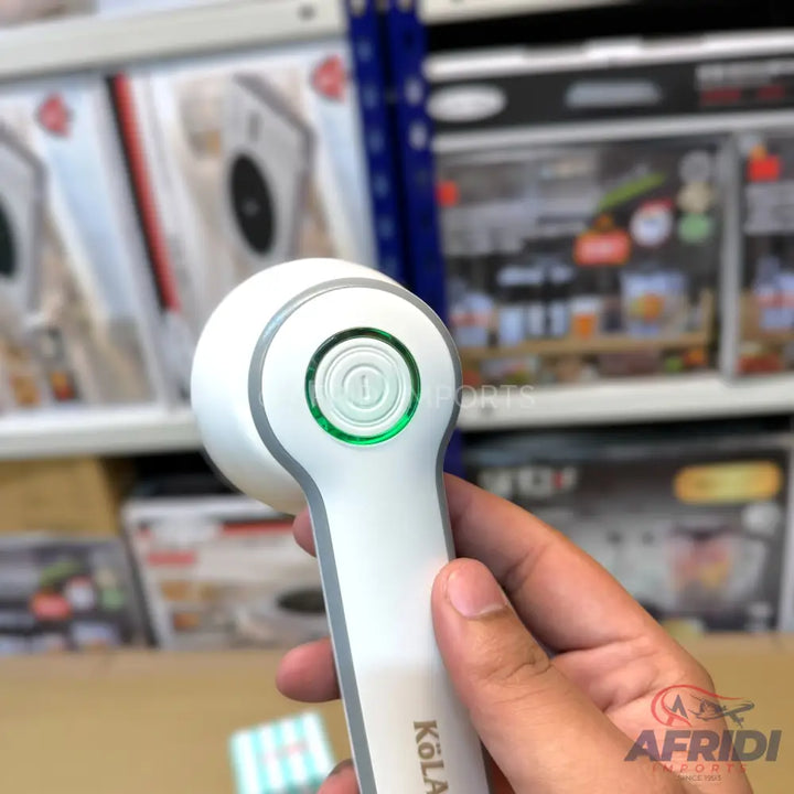 White and grey handheld lint remover with a green-lit power button.