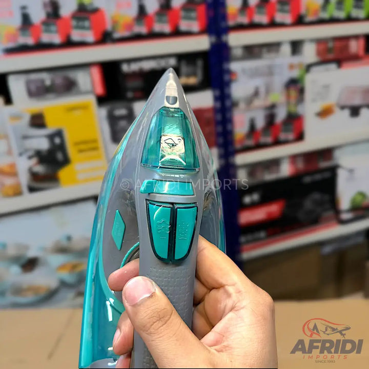 Teal and gray steam iron with a pointed tip, transparent water tank, and control buttons on the handle.